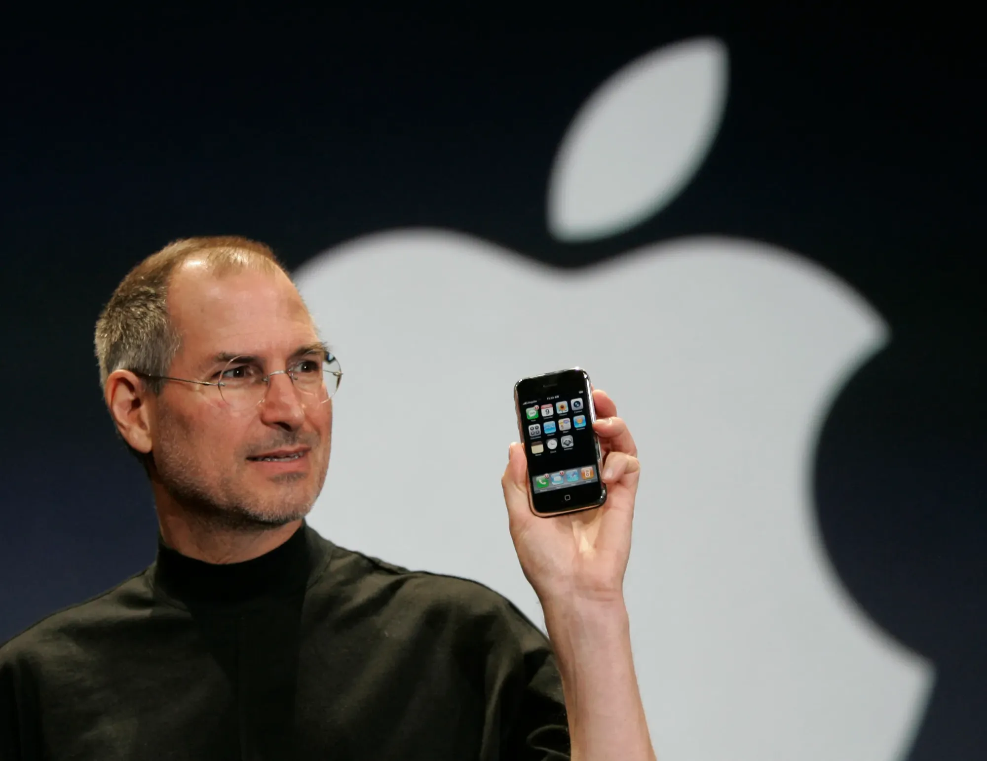 Steve Jobs sentado com o primeiro Macintosh nas pernas