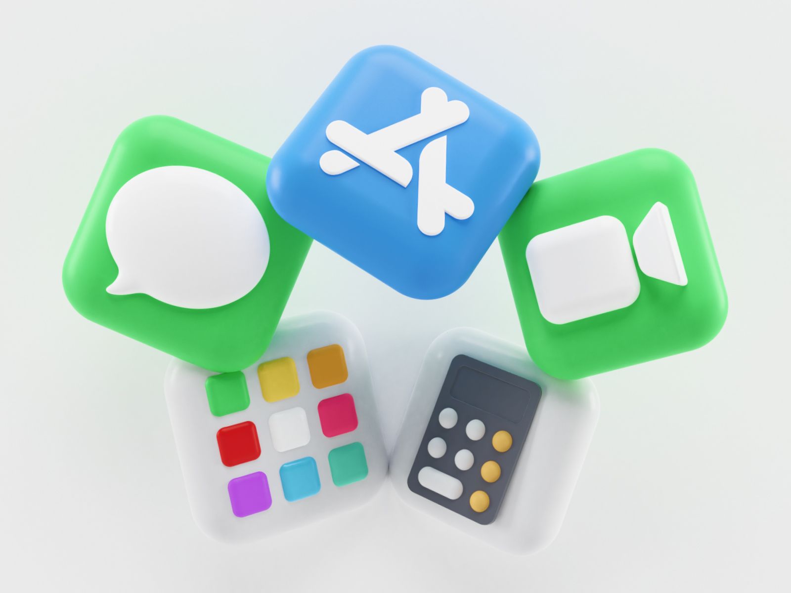 5 ícones em forma de cubo dispostos em círculo. A partir do centro, no sentido dos ponteiros do relógio, vê-se: App Store, FaceTime, Calculadora, um ícone com 9 quadrados de várias cores e, por último, mais à esquerda, as Mensagens.