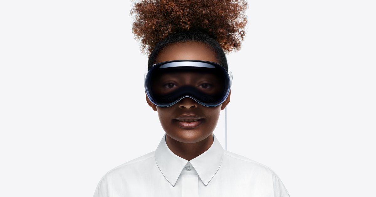 Pessoa de frente, com o Apple Vision Pro colocado, mas com os olhos visíveis, através da funcionalidade EyeSight.