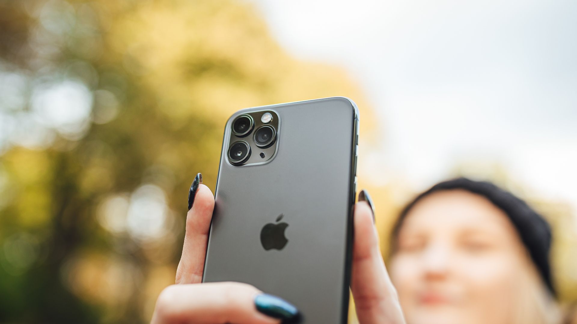 Pessoa com o rosto desfocadoa tirar uma selfie com um iPhone.